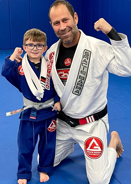 Small Kid earning a Brazilian Jiu Jitsu belt with his teacher
